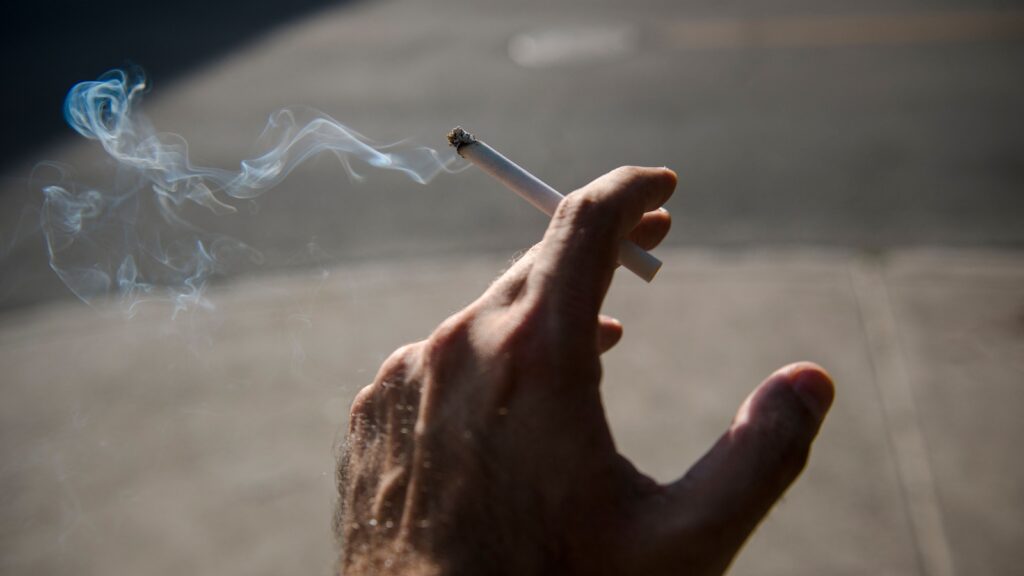 A cigarette emitting less smoke, symbolizing reduced nicotine