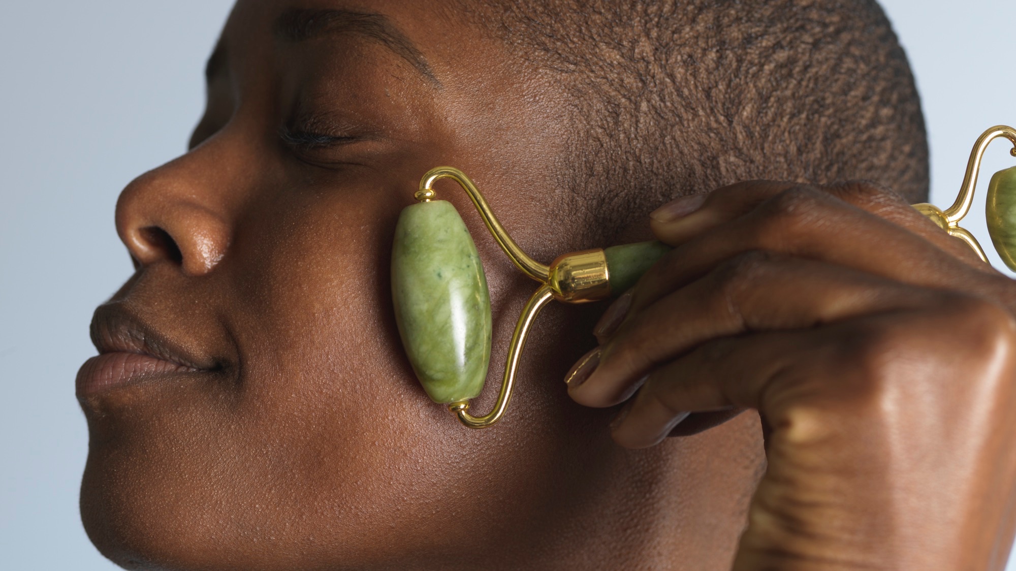 A jade face roller on a serene background