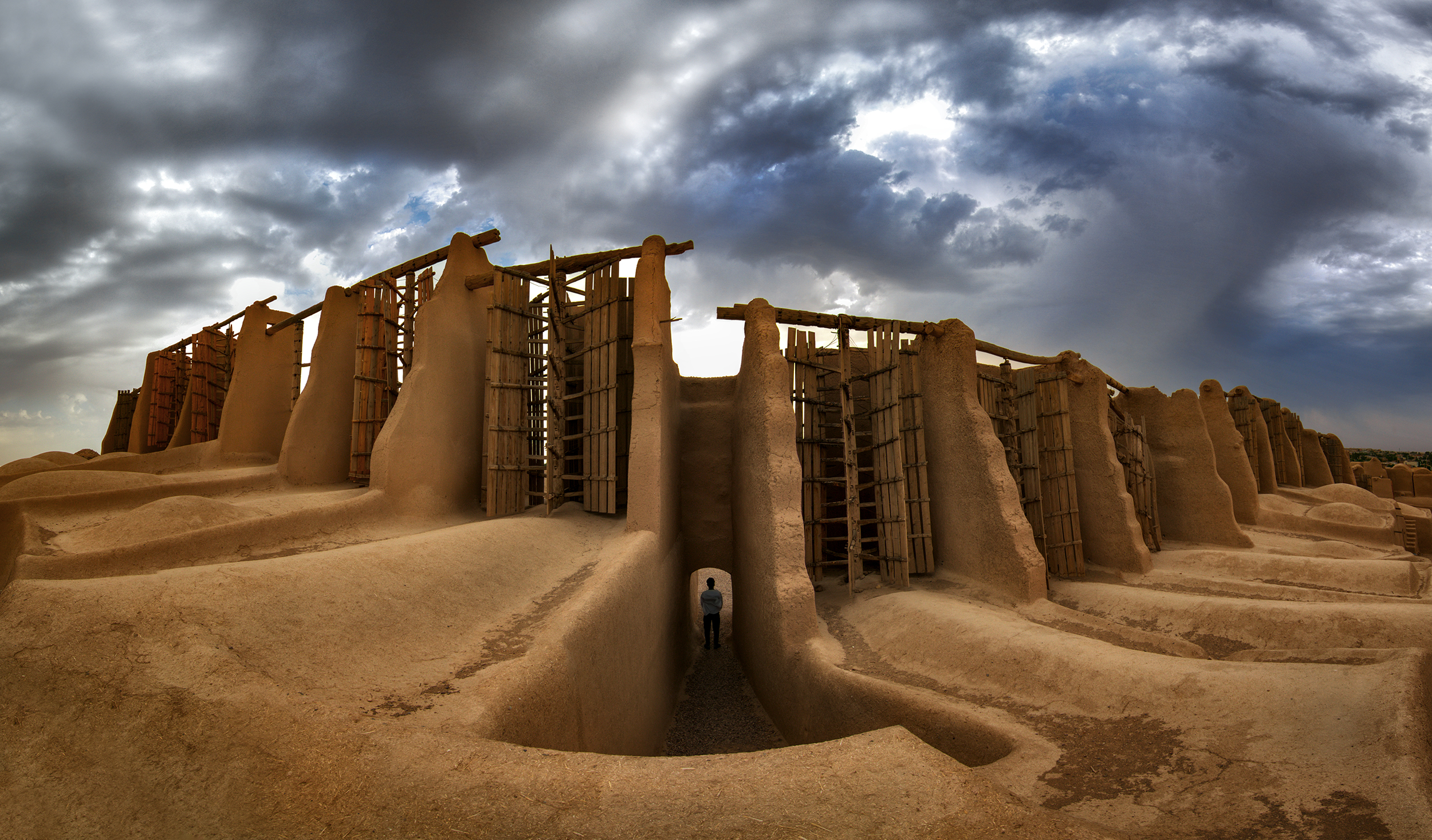 An image of ancient windmills turning in the desert winds under a clear sky.