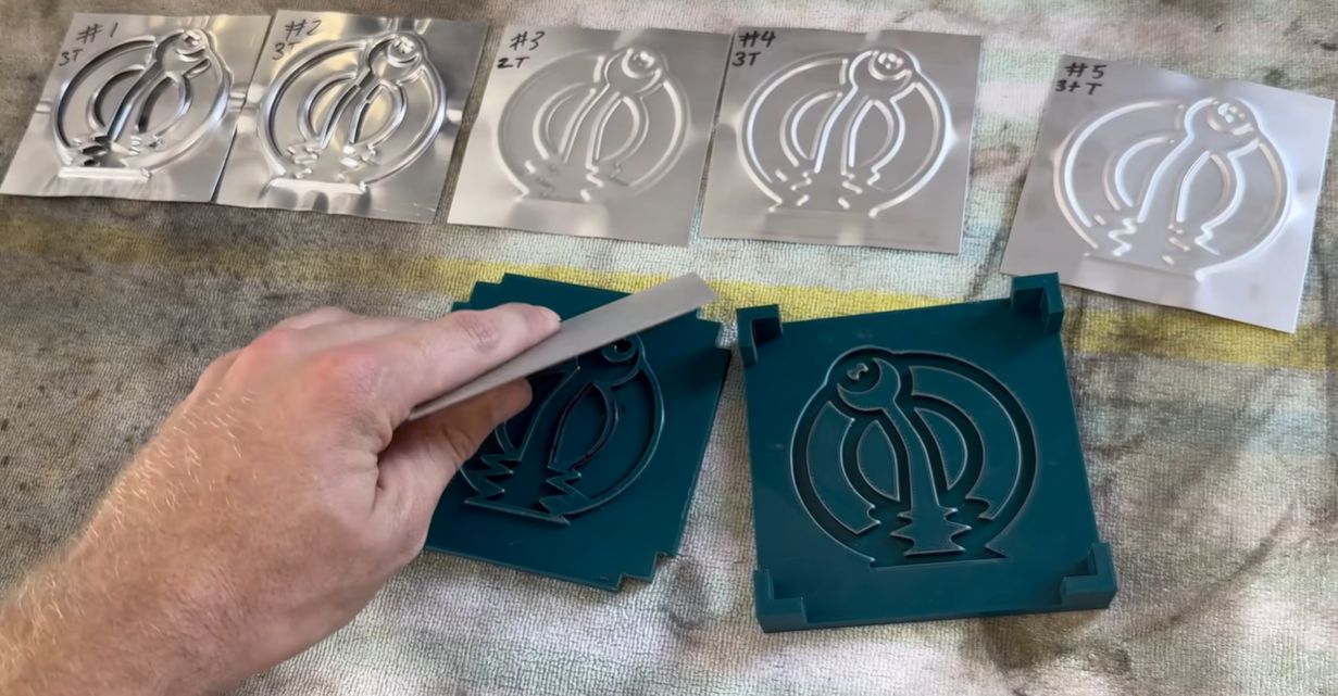 A 3D printed die pressing a logo into sheet metal