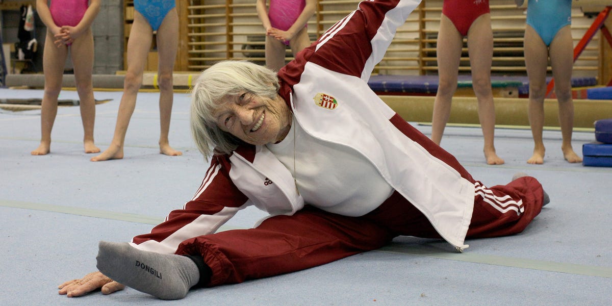 An Olympic gold medal resting on a timeless hourglass symbolizing longevity and perseverance