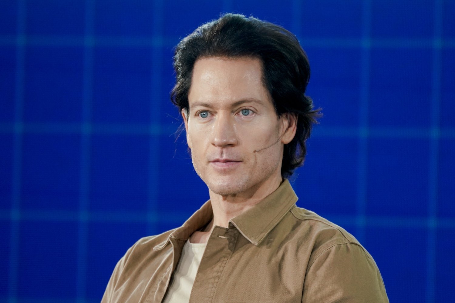 A thoughtful individual examining a pill bottle with a questioning expression against a futuristic background