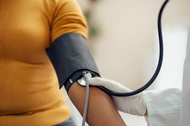 Heart shape with a blood pressure cuff symbolizing hypertension treatment
